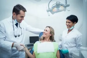 un paciente le da la mano a un dentista