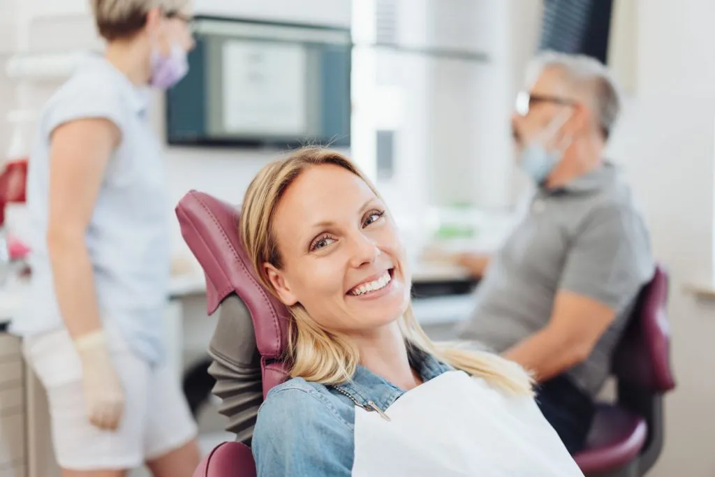 una mujer sonríe en un sillón dental