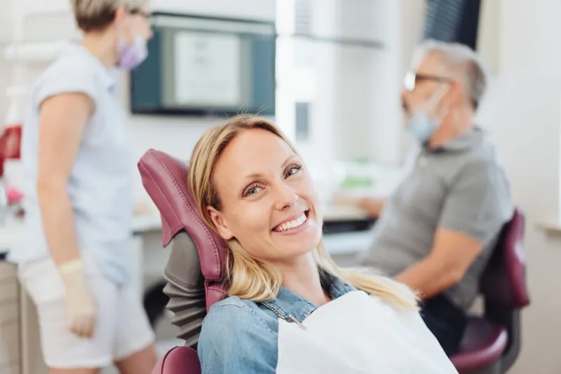 a woman smiles in a dental chair